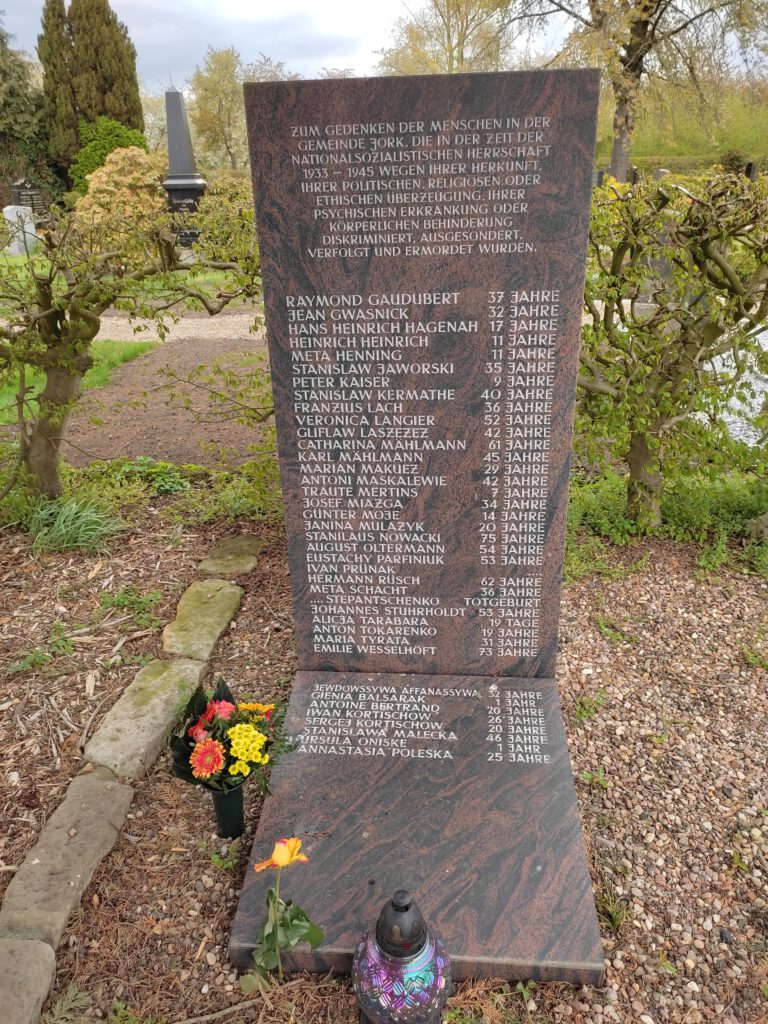 8. Mai 2021: Menschen gedenken mit Blumen der Opfer des Nationalsozialismus auf dem Jorker Friedhof (Jorkerfelde)